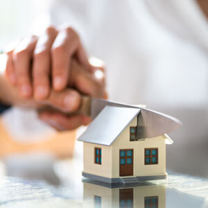 Property settlement concept with house model being cut.